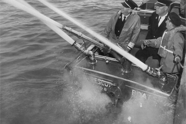 Fire Chief Ray May and Fire Inspector Emmett Byrne at demonstration of Fire Rescue Boat on Windsor waterfront, 1961